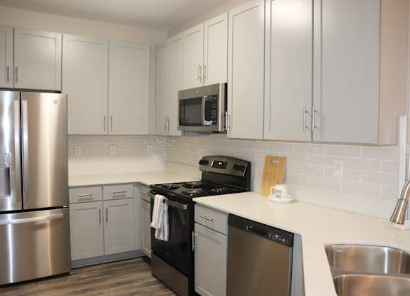 A kitchen with white cabinets and a stainless steel refrigerator at Carlton Park Apartment Homes in Flowood, MS