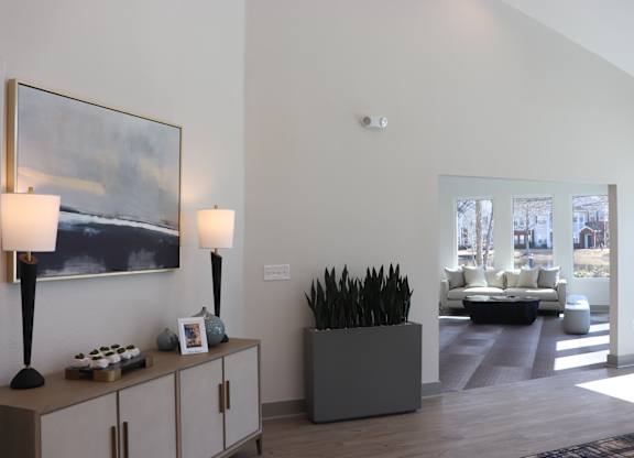 A living room with a painting on the wall and a couch in the background 
at Carlton Park Apartment Homes in Flowood, MS