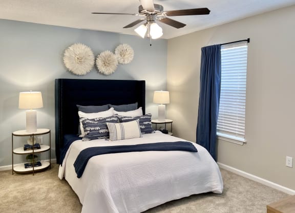 a bedroom with a bed and a ceiling fan at Reserve at Park Place Apartments, Hattiesburg