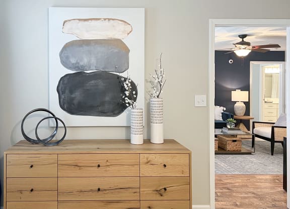 a living room with a painting on the wall and a wooden dresser at Reserve at Park Place Apartments, Hattiesburg, 39402