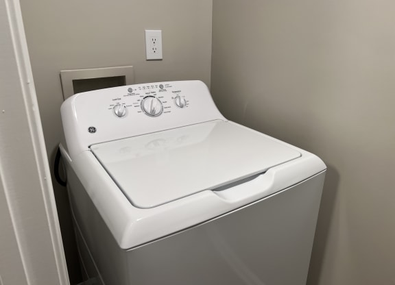 a white washer and dryer in a laundry room at Reserve at Park Place Apartments, Mississippi