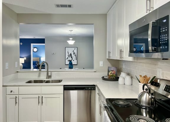 a kitchen with white cabinets and a sink and a stove at Reserve at Park Place Apartments, Hattiesburg, MS