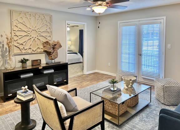 an empty living room with a ceiling fan and a glass table at Reserve at Park Place Apartments, Hattiesburg, Mississippi