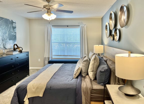 a bedroom with a large bed and a ceiling fan at Reserve at Park Place Apartments, Hattiesburg, MS, 39402