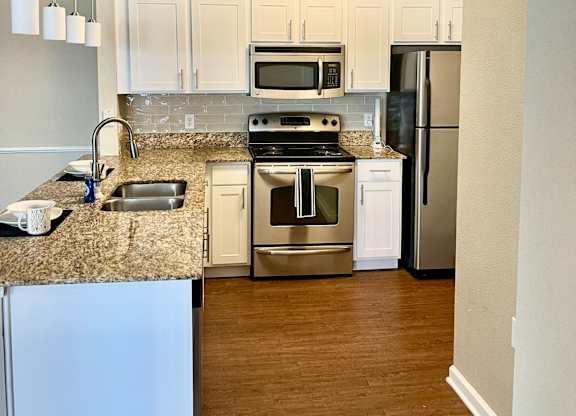 A kitchen with white cabinets and stainless steel appliances.