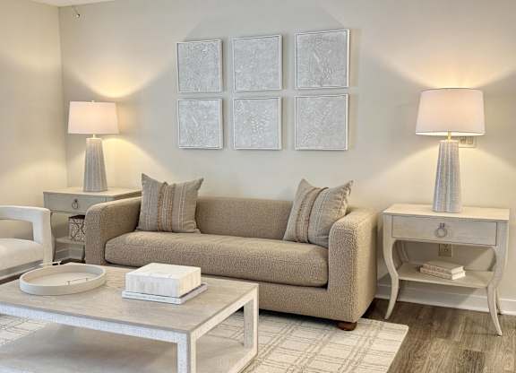 A living room with a beige couch, two lamps, and a coffee table at The Pointe Apartment Homes, Gautier, MS