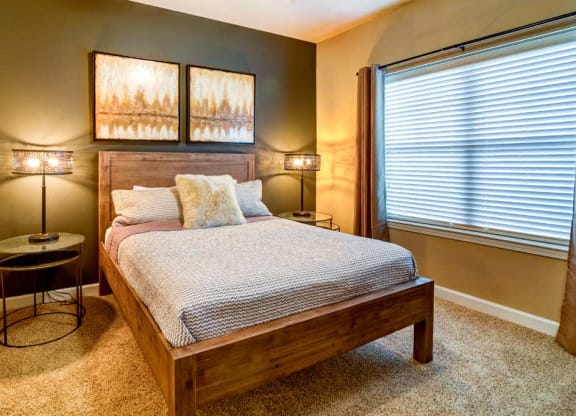 a bedroom with a bed and a window at The Retreat Apartment Homes in Williston, ND 58801