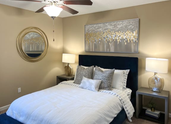 a bedroom with a large bed and a ceiling fan at Reserve of Bossier City Apartment Homes in Bossier City, LA 