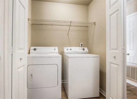 a washer and dryer in a laundry room with a closet at Reserve at Gulf Hills Apartment Homes in MS 39564