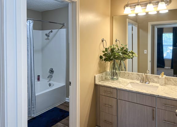 a bathroom with a shower and a sink and a mirror at Reserve at Bossier City in Bossier City, LA 