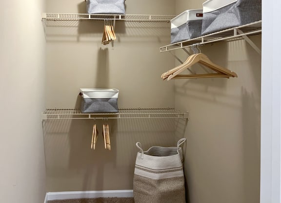 a walk in closet with shelves and baskets and a basket on the floor at Reserve of Bossier City Apartment Homes in LA 71111
