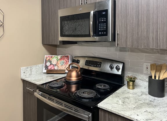 a kitchen with a stove and a microwave at Reserve of Bossier City Apartment Homes in Bossier City, LA 71111