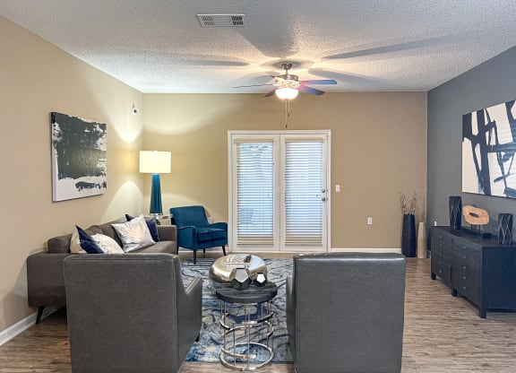 a living room with couches and a ceiling fan at Canebrake Apartment Homes in Shreveport, Louisiana