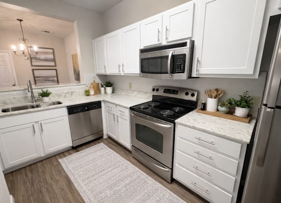 A modern kitchen with white cabinets and stainless steel appliances.