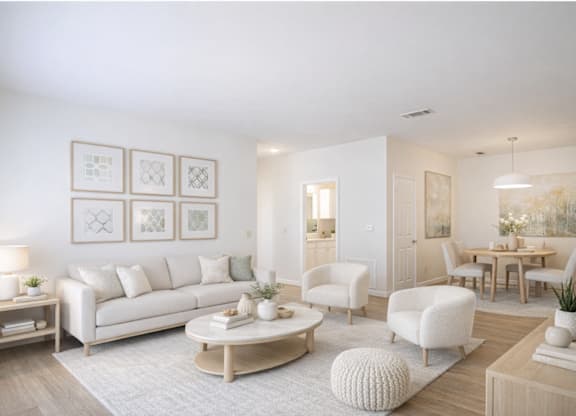 A living room with a white sofa, a coffee table, and a dining table with chairs.