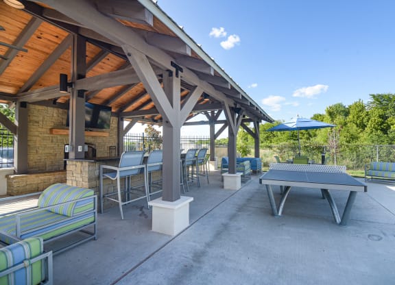 a patio with a ping pong table and tables at Canebrake Apartment Homes in Shreveport, 71115