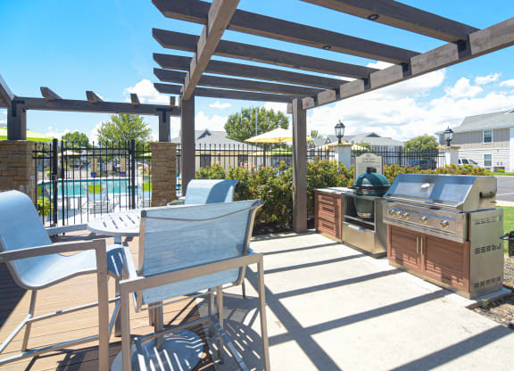 a patio with a barbecue grill and a table with chairs at Reserve of Bossier City Apartment Homes in Bossier City, LA 71111