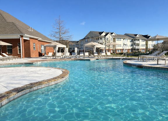 A large swimming pool in front of a resort.