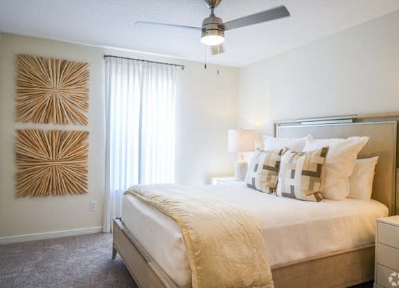 a bedroom with a large bed and a ceiling fan at The Vineyard at Castlewoods Apartment Homes in Brandon, Mississippi 39047