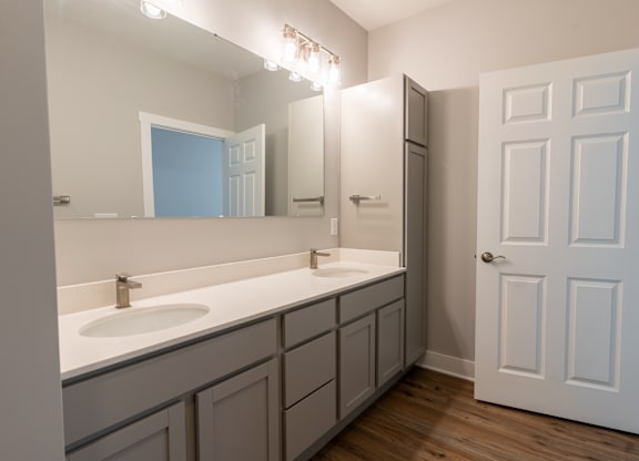 an empty bathroom with two sinks and a mirror
