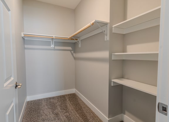 a walk in closet with shelves and a door