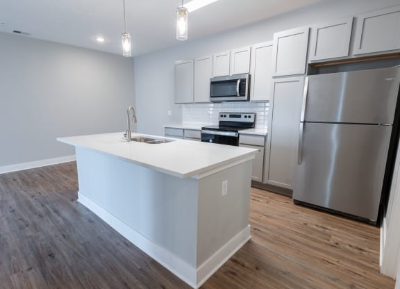 a kitchen with a large island and stainless steel appliances