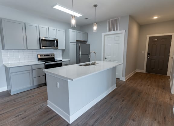 an open kitchen with a large island and white cabinets
