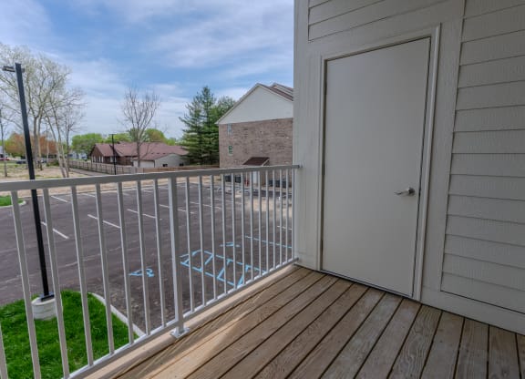 the balcony has a door to the yard and a view of the street