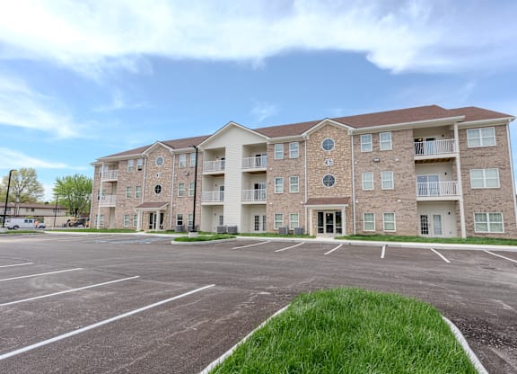 an empty parking lot in front of an apartment building
