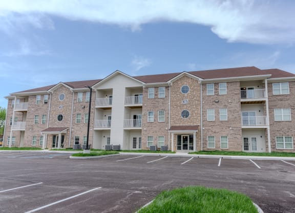 an empty parking lot in front of an apartment building