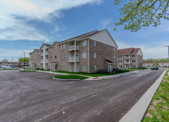 an empty parking lot in front of an apartment building