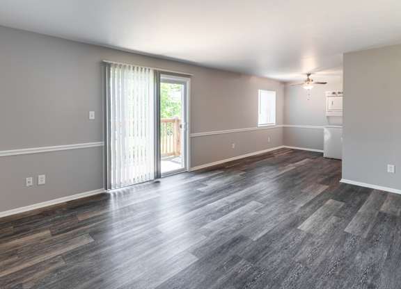 an empty living room with a sliding glass door to a balcony at Pickwick Farms Apartments, Indianapolis, 46260