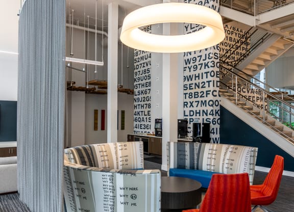 the lobby of a library with a red chair and a table
