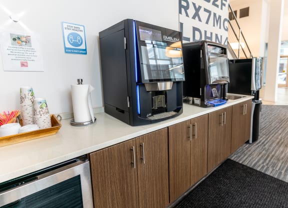 a counter with coffee machines on it in a break room