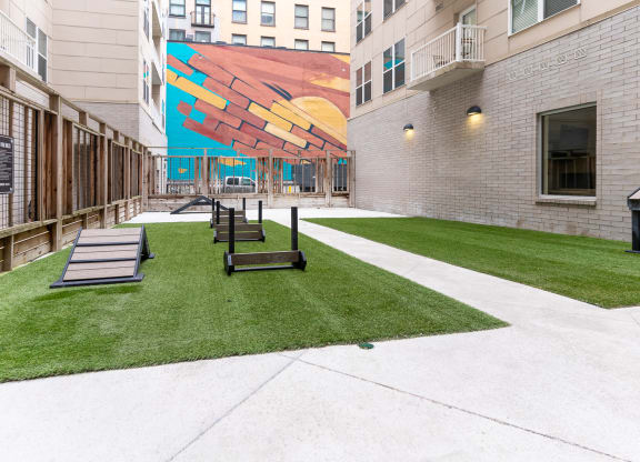 a courtyard with benches and a mural on the side of a building