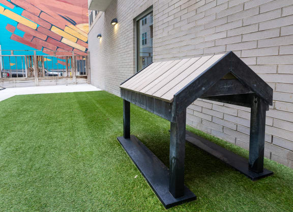 a bench in the yard of a building with artificial grass