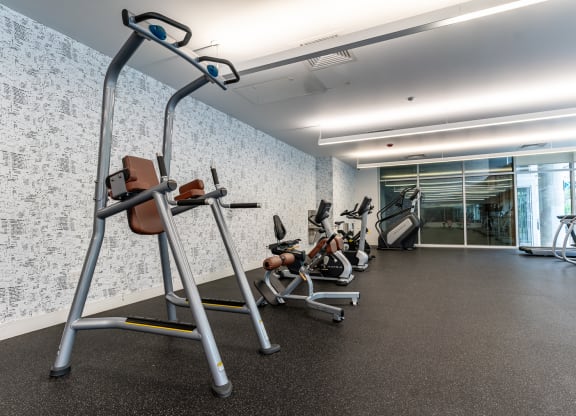 a gym with various exercise equipment in a building with a glass door