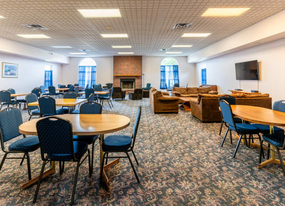 a large room with tables and chairs and a fire place