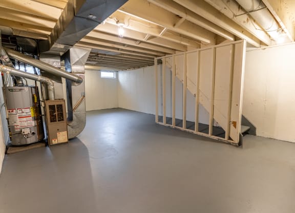 a room with white walls and a staircase in the corner