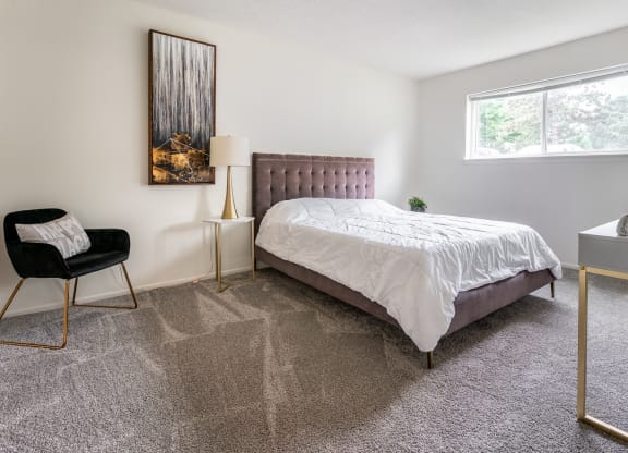 an apartment bedroom with a bed and a window