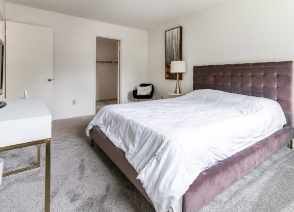 a bedroom with a bed and a desk and a tv