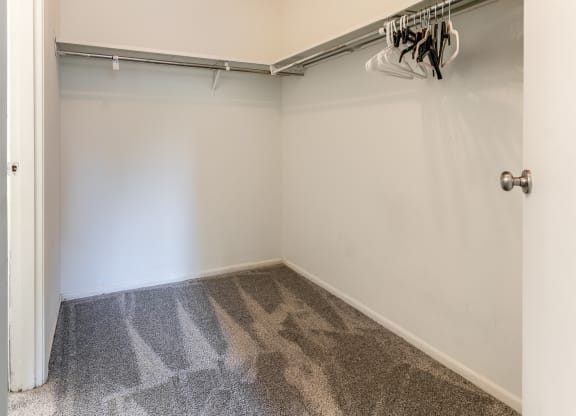 a room with a carpeted floor and a white wall with a garage door