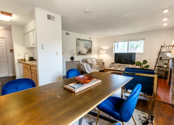 a living room and dining room with a wooden table and blue chairs