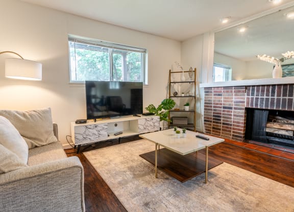 a living room with a couch and a coffee table and a fireplace