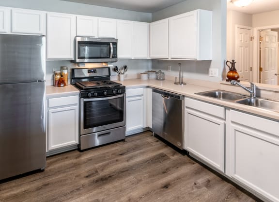 a kitchen with stainless steel appliances and white cabinets