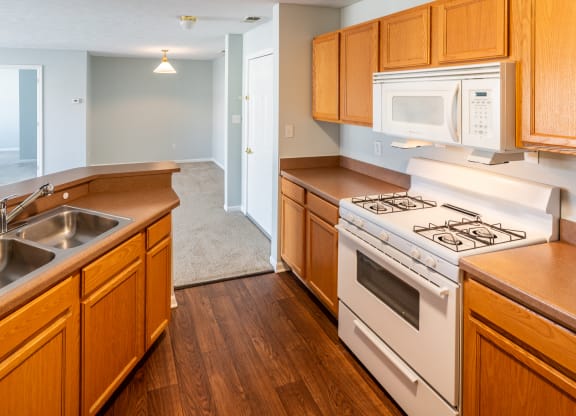 a kitchen with wooden cabinets and white appliances and a sink