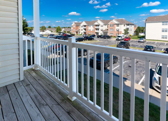 a balcony with a view of a parking lot and houses