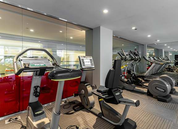 a gym with cardio machines and weights on the floor