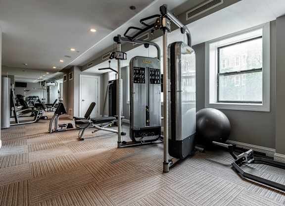 a gym with exercise machines and weights on the floor
