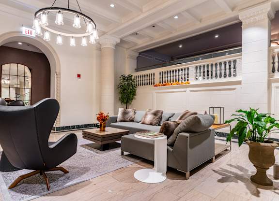the lobby of a hotel with couches and a chair